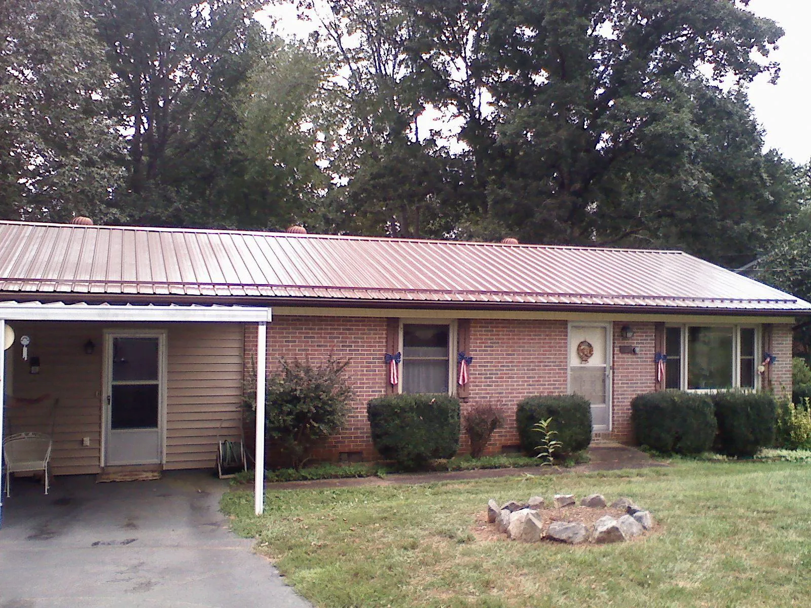 Bronze metal roof and carport on a brick ranch home — Roof Repair work by our crew in Grays River